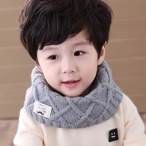 Detail of grey knitted kids neck warmer featuring a diamond pattern and beard logo tag