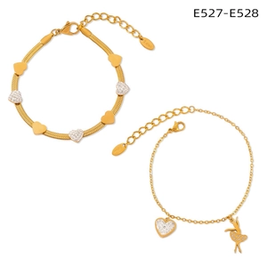 Detail of gold heart charms and ballerina pendant on stainless steel bracelets