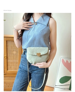 Mannequin portant un sac selle vert menthe avec boucle cœur dorée et bandoulière
