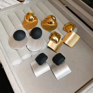 Orecchini geometrici minimalisti in oro e argento in una scatola regalo in velluto