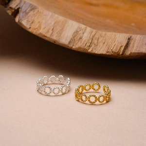 Detailed macro of vintage twisted beaded silver and gold stackable open rings on wood