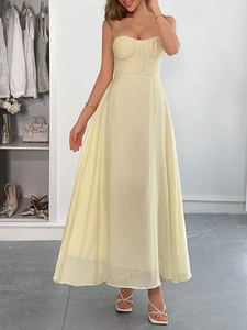 Full view of elegant yellow pleated camisole maxi dress on model in a soft dressing room