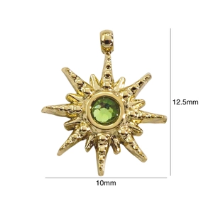 Detail view of a 14k gold star pendant with a green zircon showing 12.5mm size
