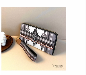 Detail view of ethnic geometric pattern on long zipper purse with a gold metal clasp