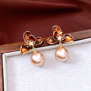 Detail of vintage flower earring with amber enamel petals, crystal core and faux pearl