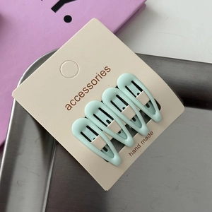 Close-up of four light green matte star hair clips on handmade accessories card