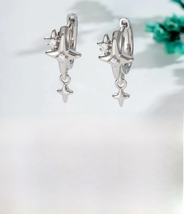 Macro shot of silver star drop hoop earrings with sparkling cubic zirconia inlay detail