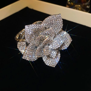 Macro view of adjustable floral ring with pavé diamond petals and twisted rope band texture
