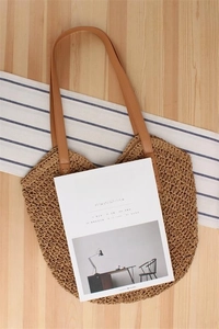 Detail of hand-woven hollow mesh texture on a brown paper rope beach tote bag