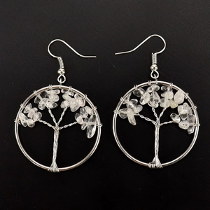 Detailed close-up of handmade Tree of Life wire wrap earrings with clear crystal stones