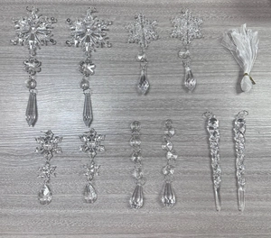 Detailed set of 10 clear acrylic Christmas ornaments with snowflakes and icicles on wood
