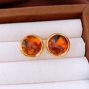 Vintage amber resin earrings with gold metallic edge displayed in jewelry box