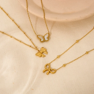 Détails de trois colliers papillon en or 18 carats avec incrustations en nacre et perles