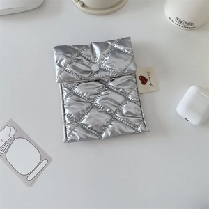 Close-up of a silver quilted sanitary pouch with heart tag and white button closure