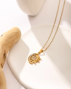 Close-up of 18K gold plated stainless steel sun and moon pendant with shimmering crystals