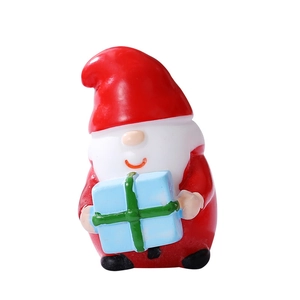 Miniature resin Santa Claus figurine holding a blue gift box with green ribbon décor