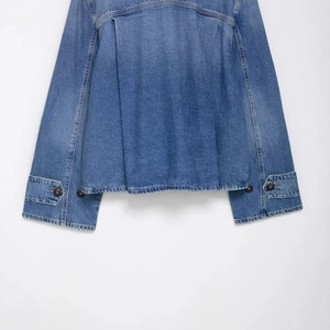 Blaue Denim-Jacke mit Rückenfalten-Design und Metallknöpfen auf weißem Hintergrund