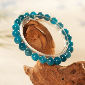 Macro detail of blue apatite crystal beaded bracelet on natural wood stand