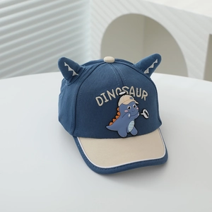 Detail of dinosaur baseball cap featuring 3D horns and embroidered lettering on navy fabric