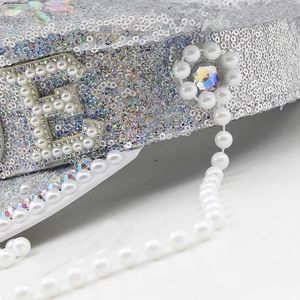 Detailed macro view of sparkling silver sequins and white pearls on a bridal party hat