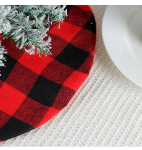 Detailed texture of red and black buffalo plaid Christmas tree skirt with pine needles
