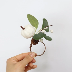 Detail of white pumpkin napkin ring with eucalyptus leaves and pinecone for fall decor