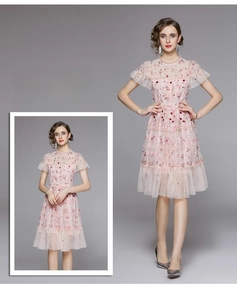 Détail de la broderie florale sur robe en tulle rose avec manches à volants et jupon