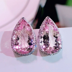 Macro detail of pear-shaped pink gemstone earrings with silver halo zircon setting