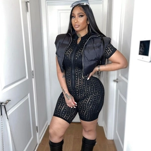 Detail of mesh hollow-out bodysuit paired with short black puffer vest and long boots