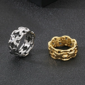 Macro detail of men's hollow X-pattern rings in silver and gold on black texture