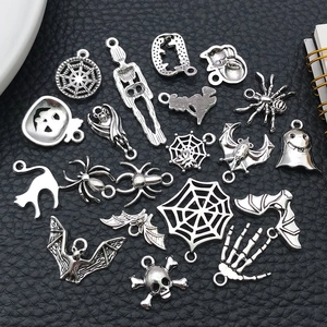 Close-up of antique silver Halloween charms including skulls, spiders and bats