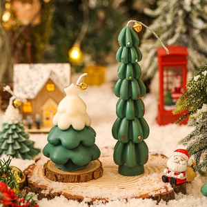Mini Christmas tree scented candles with gold bells on snow-covered wooden base