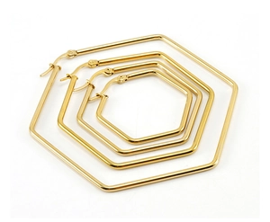 Macro detail of four assorted sizes of golden hexagonal hoop earrings in nested layout