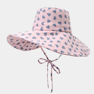 Pink sun hat with blue heart patterns featuring a large brim and matching chin strap bow
