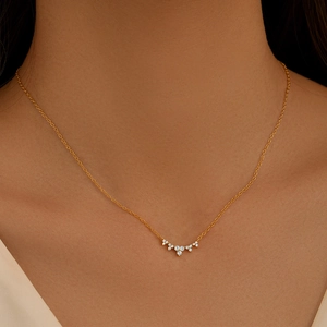 Close-up of a gold smile pendant necklace with sparkling diamonds worn by a model