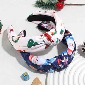 Detail of Christmas knot headbands with Santa Claus and tree prints on festive backdrop