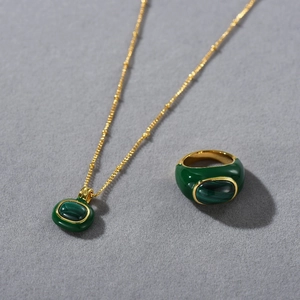 Detailed view of 18k gold plated necklace and ring set with oval green malachite stones