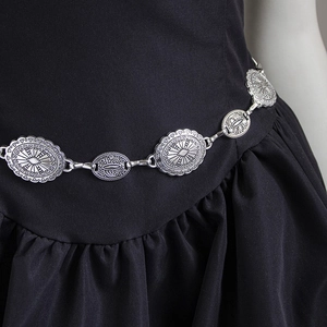 Bohemian silver metal waist chain with vintage embossed oval links on a black dress