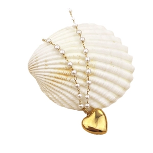 Elegant 18K gold plated heart pendant necklace with white pearls on a shell display