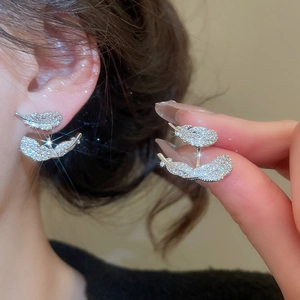Detailed macro view of silver feather earrings with cubic zirconia inlay and refined shine