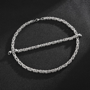 Polished silver stainless steel Byzantine chain set with necklace and bracelet on dark background