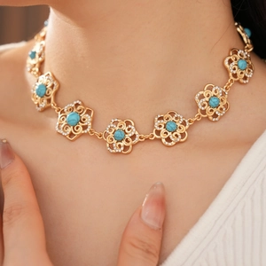 Close-up of vintage flower necklace with turquoise stone and diamond accents