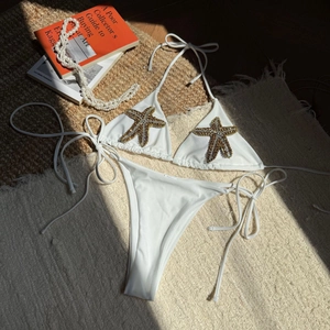 Detail of white bikini set with gold starfish embroidery and adjustable side ties