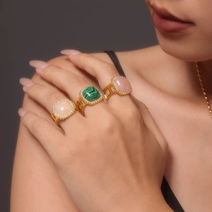 Three gold PVD coated rings with square malachite and pink zircon on a woman's hand