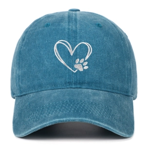 Close-up of heart and dog paw embroidery on washed blue denim baseball cap