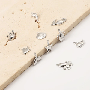 Macro shot of silver stainless steel marine pendants featuring starfish and dolphin details