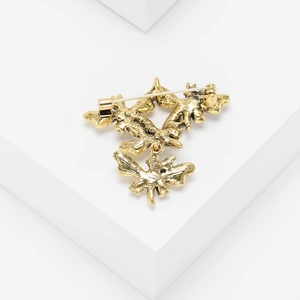 Detailed back view of vintage golden butterfly brooch showing safety pin and metal clasp