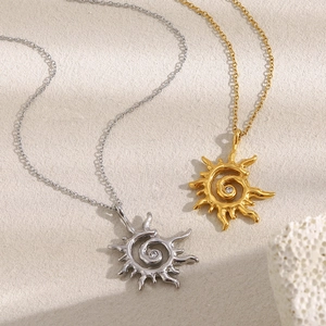 Détail des colliers à pendentif soleil en or et argent avec zircon sur papier texturé