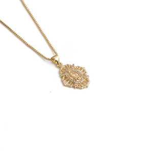 Collier doré avec pendentif relief portrait ajouré et pierres zircons sur fond blanc