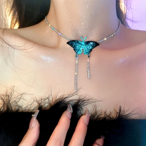 Détail du collier choker papillon avec ailes dégradées bleues et pompons brillants